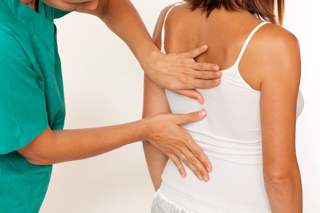 the doctor examines the back for pain in the shoulder blade area